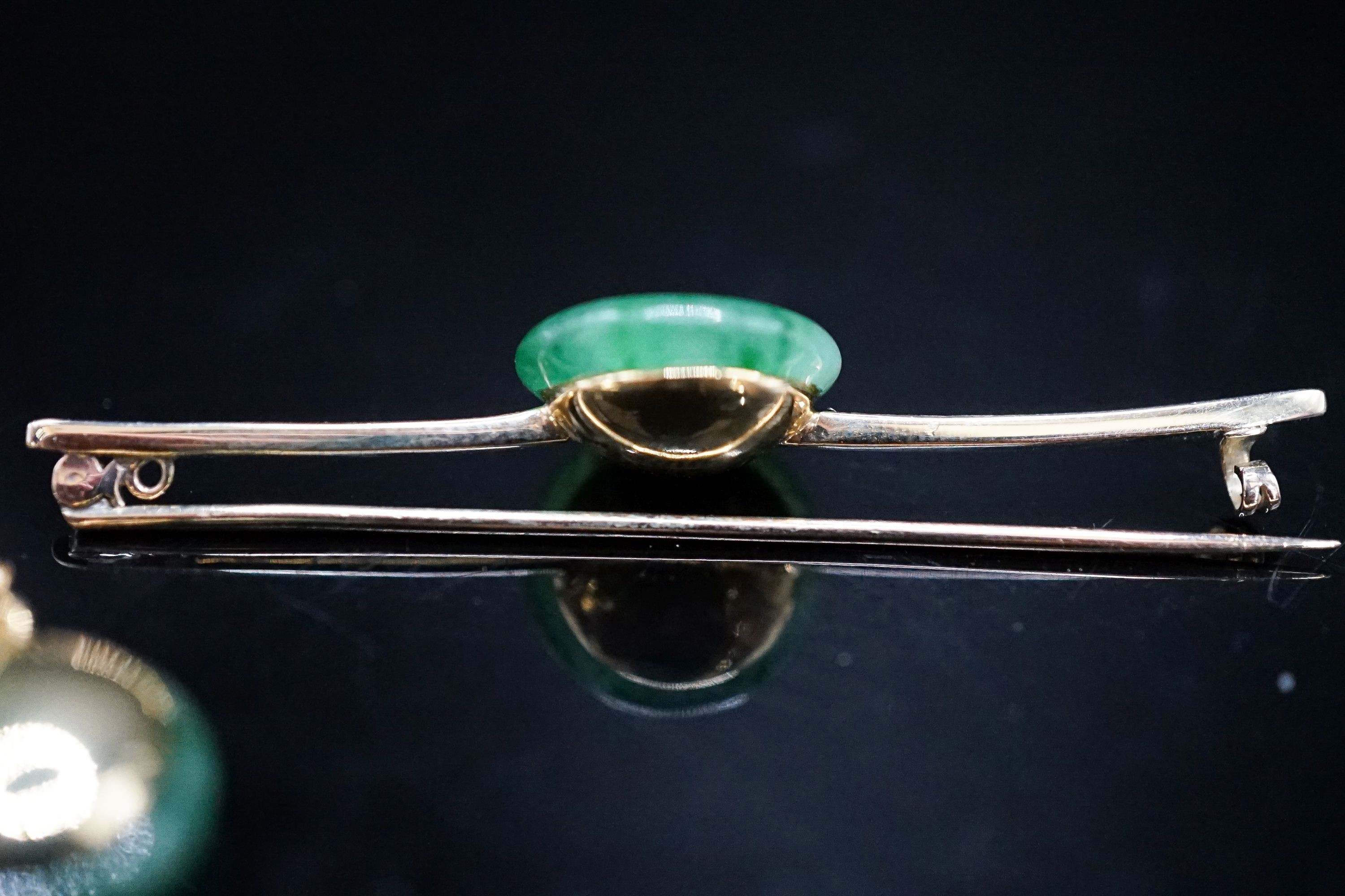 A yellow metal mounted jade and diamond set circular pendant, 14mm, on a 585 rope twist chain and a similar jade and diamond set bar brooch, 58mm, gross weight 12.8 grams